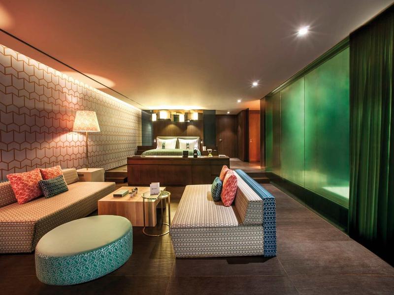 Moderní hotelový salón s pohovkami, konferenčním stolkem a teplým osvětlením.