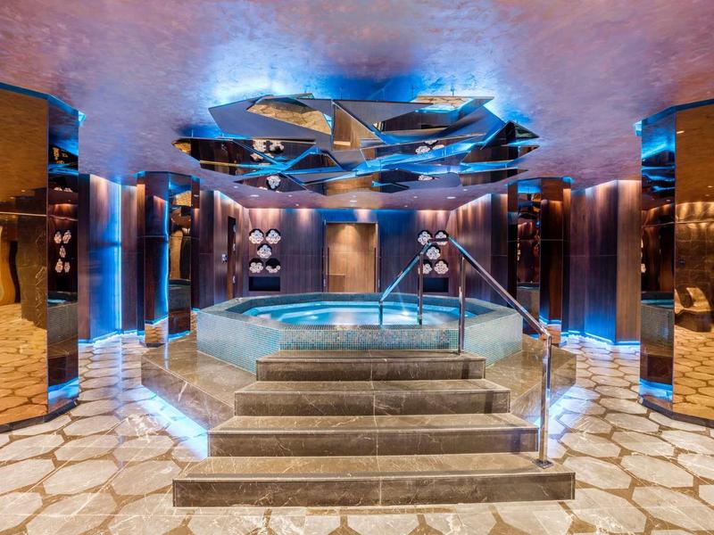 Luxusní interiér s vyhřívaným bazénem a moderním osvětlením.