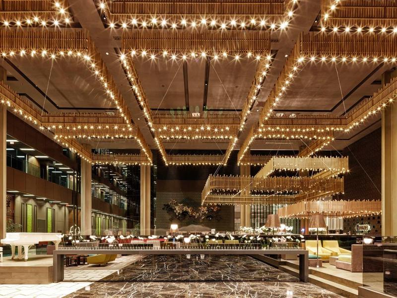 Luxusní hotelová hala s teplým osvětlením a moderním designem.