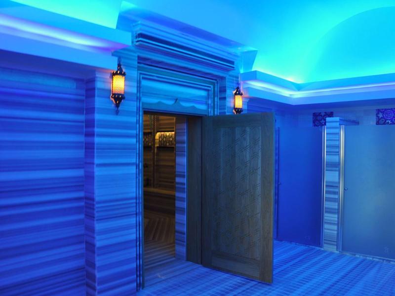 Área de bienestar azul con sauna abierta y ascensores de diseño elegante.