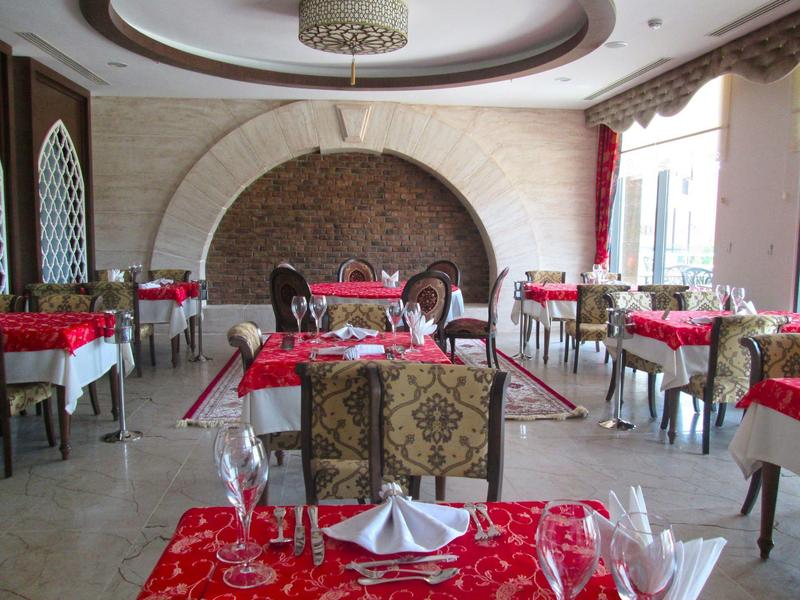 Elegante restaurante con mesas con manteles rojos y paredes claras en un hotel.