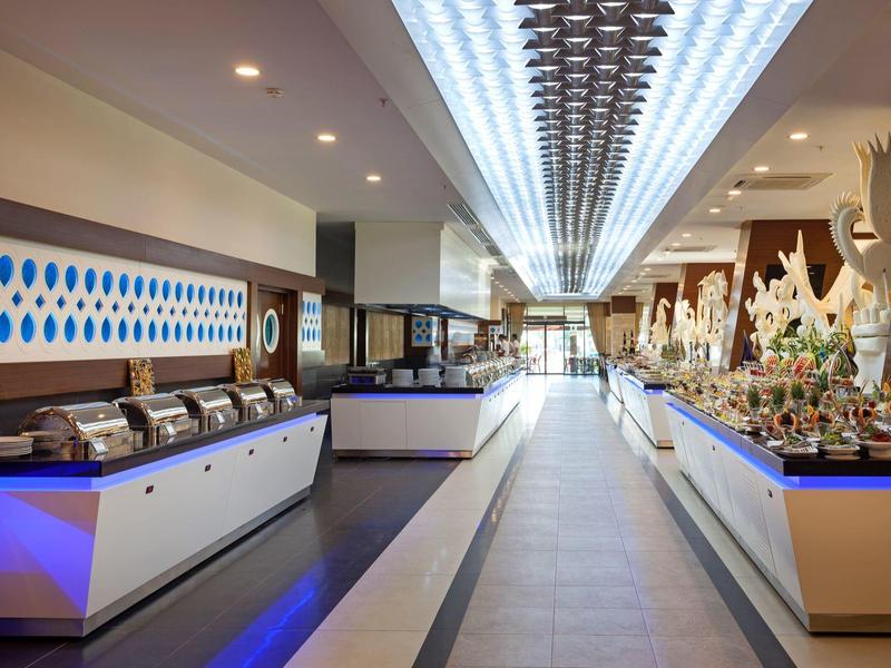 Moderna zona de buffet hotelero con mostradores iluminados y decoración elegante bajo luz de techo.