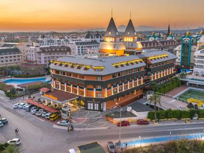 Un grand hôtel avec deux tours au coucher du soleil dans une ville