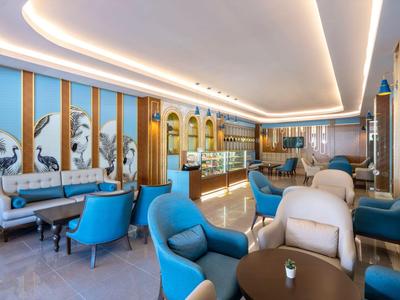 Restaurant d'hôtel moderne avec des chaises bleues, des murs clairs et un long comptoir éclairé.