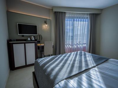 Chambre d'hôtel moderne avec lit, télévision écran plat et fenêtre donnant sur l'extérieur.