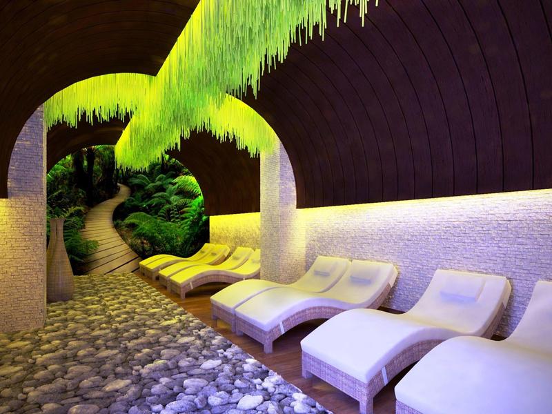 Cozy spa area with loungers, soft lighting, and green plants hanging from the ceiling.