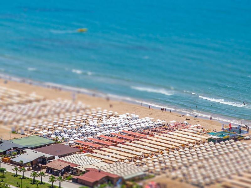 Modern furnished bedroom with double bed, armchairs, and dressing area.