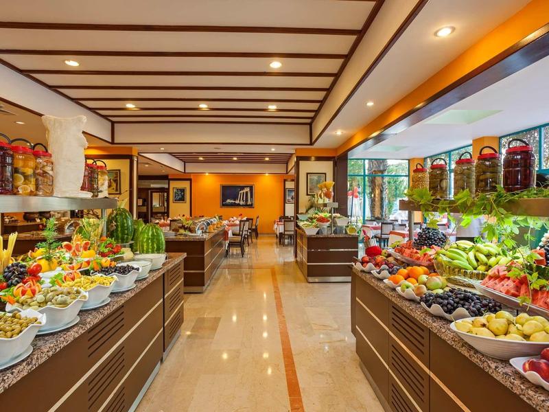 Bufet z różnorodnymi świeżymi owocami i przekąskami w jasnej restauracji.