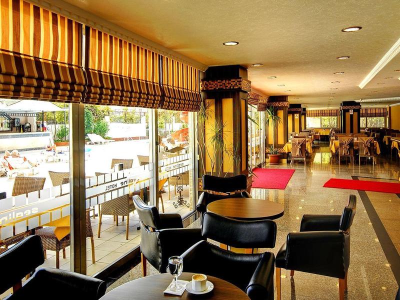 Nowoczesna kawiarnia z czarnymi fotelami, drewnianymi stolikami i dostępem do tarasu na zewnątrz w hotelu