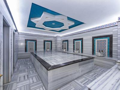 Interieur van een Turks bad met marmeren bassin en decoratieve muren.