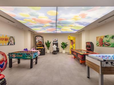 Sala giochi moderna con tavoli da calcio balilla e air hockey e illuminazione colorata sul soffitto.