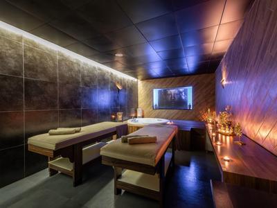 Gezellige spa-ruimte met twee massagetafels, zachte verlichting en een ontspannen sfeer.