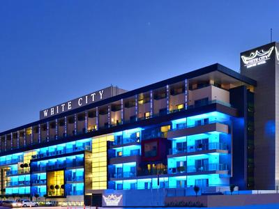 Bâtiment d'hôtel moderne la nuit avec éclairage bleu et ciel clair.