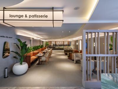 Espace lounge et pâtisserie moderne avec sièges confortables et design intérieur élégant.