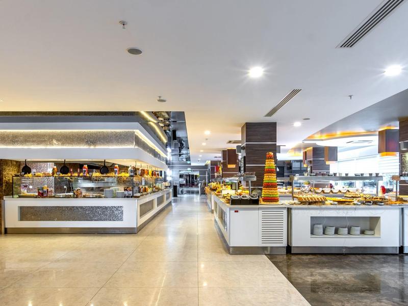 Groot modern buffetgebied met diverse gerechten en heldere verlichtingselementen.