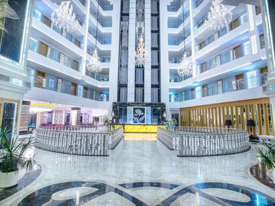 Nowoczesne, jasne lobby hotelowe z marmurową podłogą i eleganckimi miejscami do siedzenia.