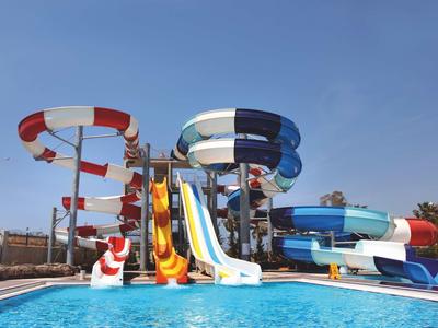 Wasserpark mit bunten Wasserrutschen über klarem Pool bei sonnigem Himmel.