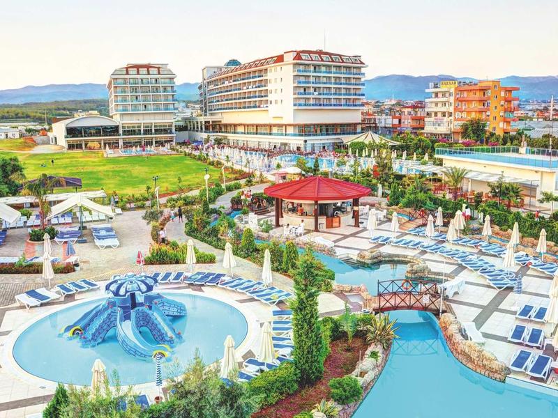 Complexe hôtelier avec piscine extérieure et zones de détente luxueuses.