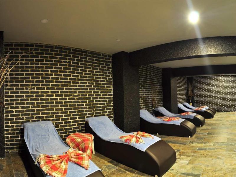 Modern wellness area with loungers, brick wall, and subdued lighting.