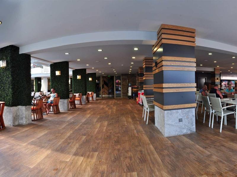 Open hotel dining area with wooden flooring, modern furniture, and skylights.
