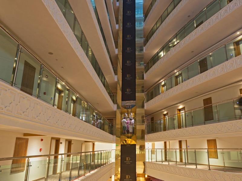 Vista de un hotel de varios pisos con ascensor de vidrio en el centro e interior moderno.