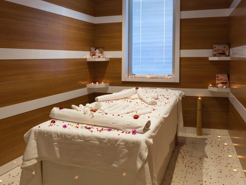 Sala de spa sencilla con mesa decorativa y revestimiento de madera en las paredes.