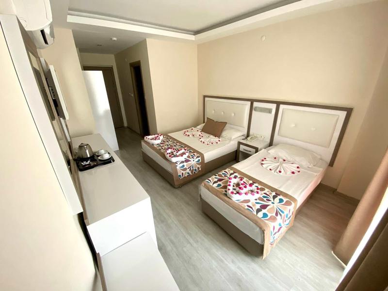 Hotel room with two single beds, each with colorful bedding and wall decor.