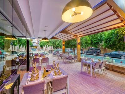 Příjemná venkovní terasa restaurace s prostřenými stoly a výhledem na zeleň.