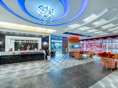 Modern hotel lobby with marble counter and cozy seating areas.