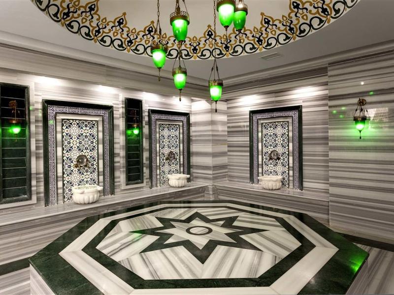 Elegant room with geometric patterns and green lighting in a hotel.
