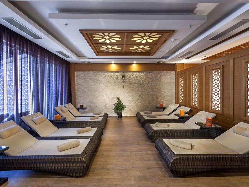 Luxurious relaxation room with lounge chairs, decorative walls, and soft lighting.