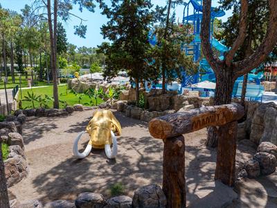 Kinderspielplatz mit Elefanten-Schaukel und Wasserrutschen im Hotelgarten.