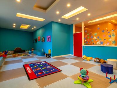 Kinderzimmer mit buntem Spielzeug und Sitzgelegenheiten in einem Hotel.