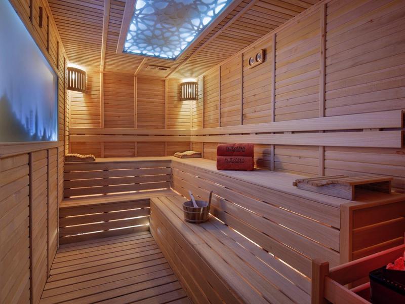 Cozy sauna with wooden benches and relaxing lighting.