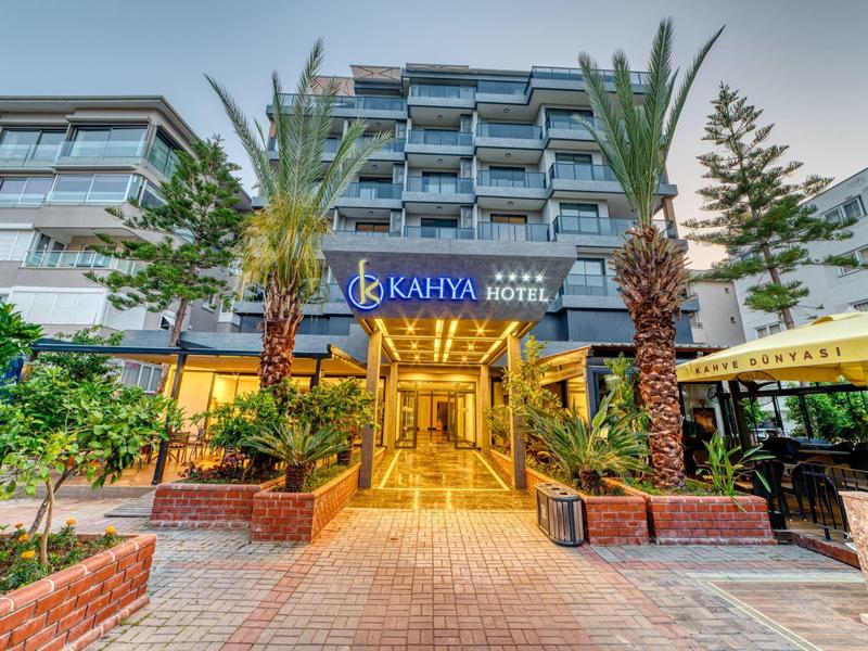 Entrance of Kahya Hotel with palm trees and outdoor area illuminated by warm lighting.
