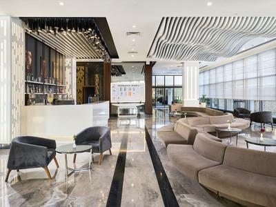 Moderní hotelový lounge s elegantním sezením a velkými okny