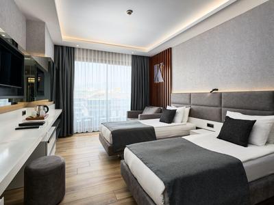 Modernes Hotelzimmer mit zwei Einzelbetten, großem Fenster und Blick nach draußen.