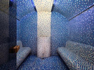 Gemütlicher Dampfraum mit blauen Mosaikfliesen und zwei Sitzbänken