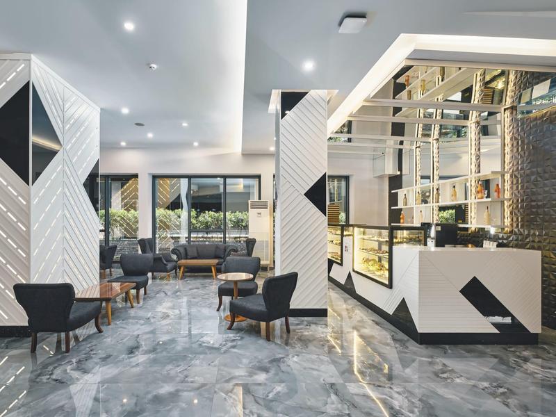 Heller Hotellobby mit modernen Sesseln und Marmorboden.