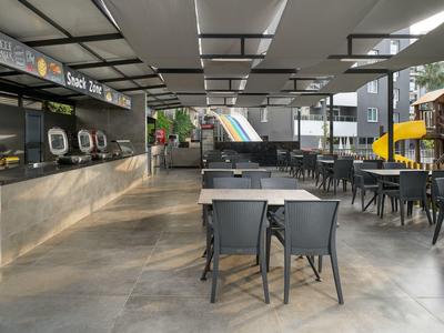 Modern open-air hotel restaurant terrace with tables, chairs, and buffet area.