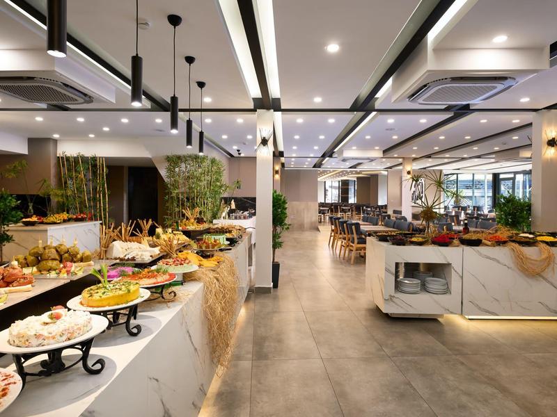 Modern restaurant with bright buffet and stylish lighting, perfect for breakfast and lunch.