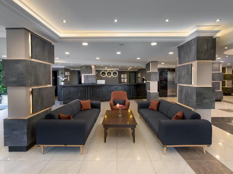Modern hotel lobby with dark sofas and elegant lighting.