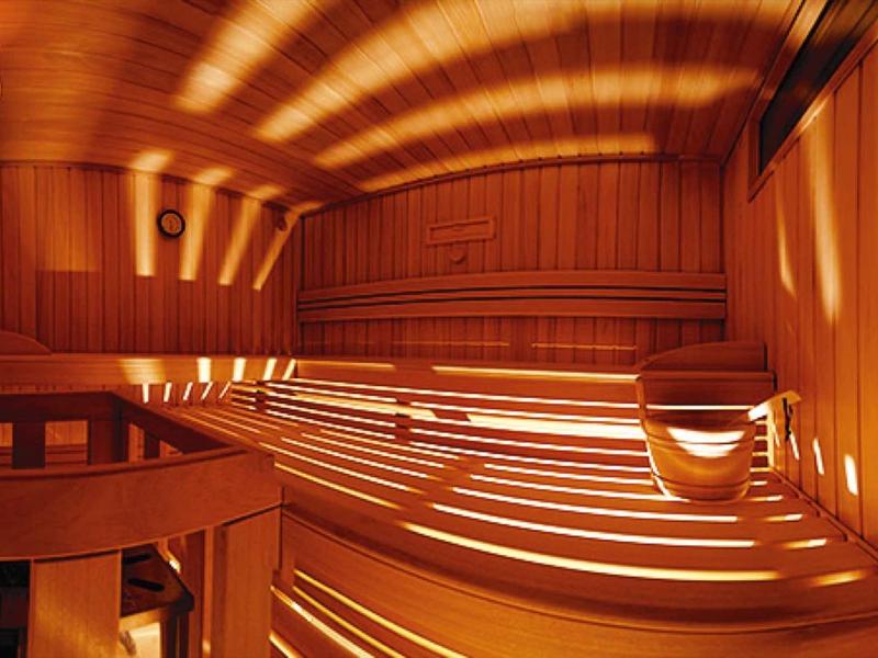 Sauna en bois avec bancs et éclairage chaleureux pour la détente à l'hôtel