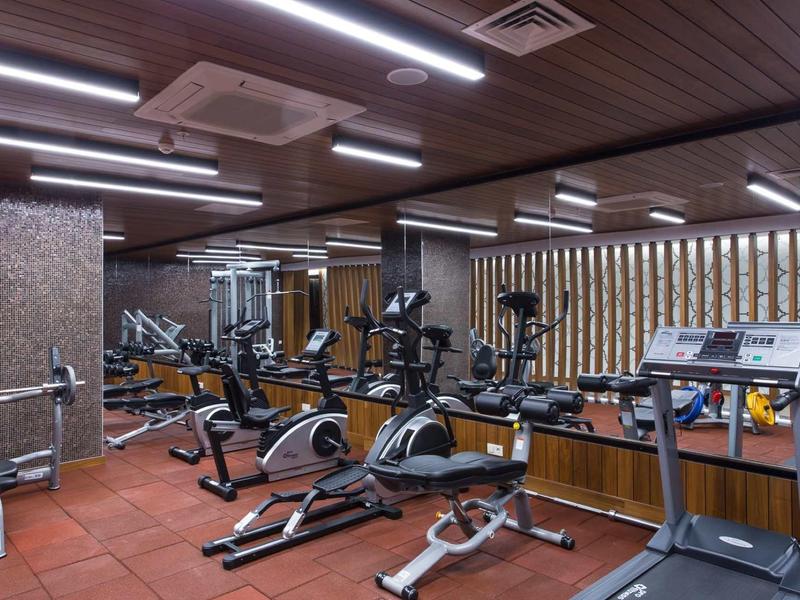 Équipements de fitness modernes dans une salle bien éclairée avec des panneaux muraux en bois.