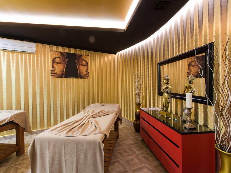 Salle de bien-être confortable avec tables de massage, lumière chaude et décoration Bouddha.