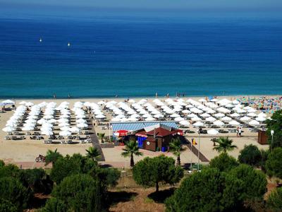 Beach with many white umbrellas and blue sea in the background
