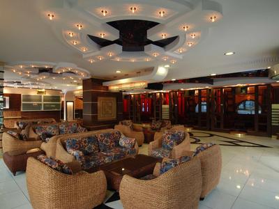 Sala de hotel elegante con asientos cómodos y iluminación decorativa en el techo.