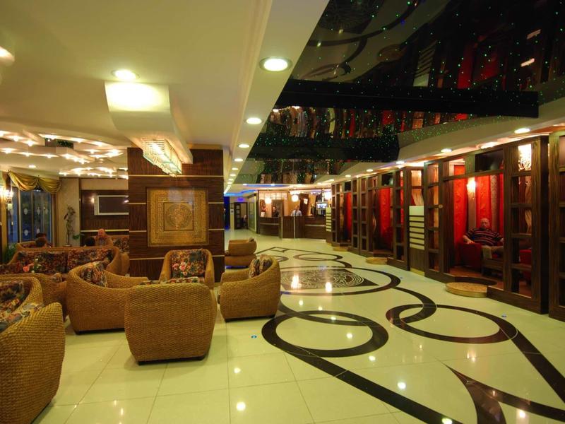 Elegant hotel lobby with modern armchairs and shiny marble floor in warm lighting.