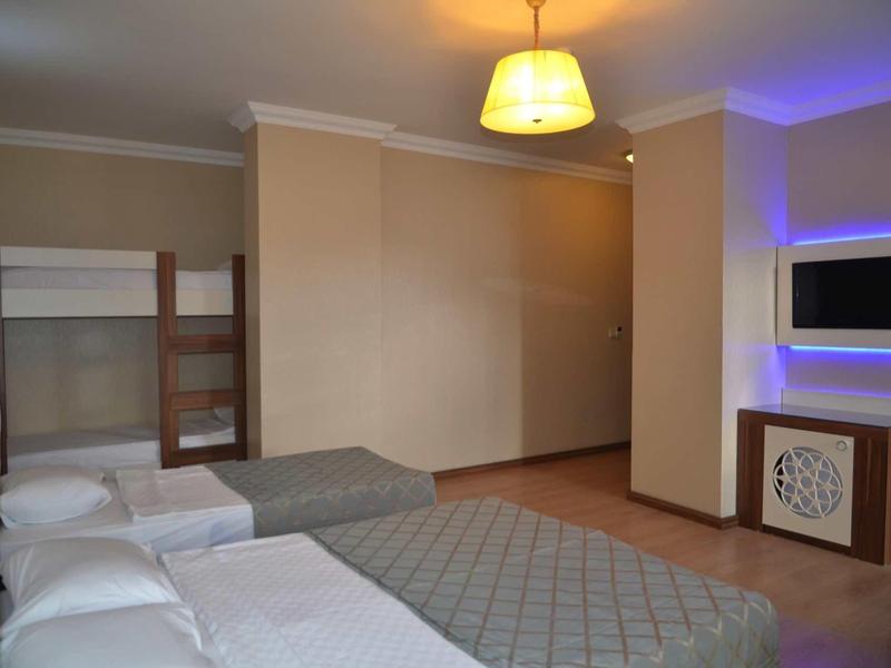 Hotel room with two single beds, built-in TV, and modern lighting elements.