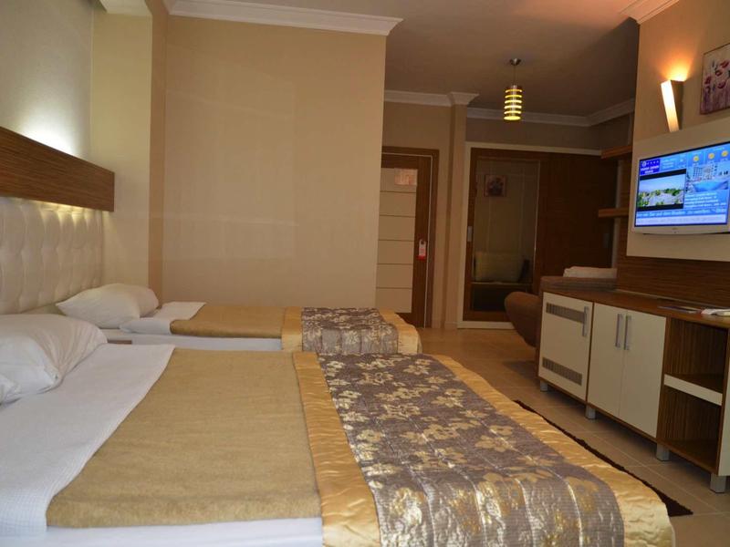 Cozy hotel room with two double beds, TV, and modern furniture.